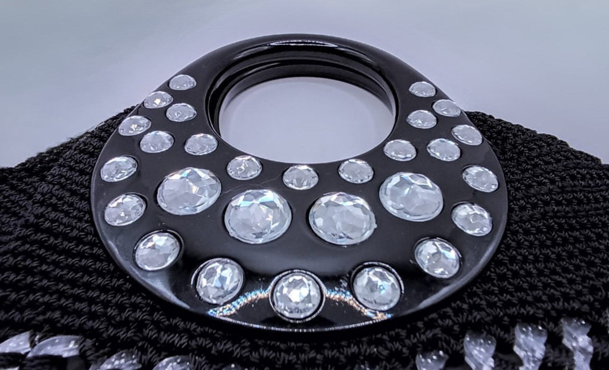 Bolsa negra crochet, gemas plateadas brillantes, con asa elegante.