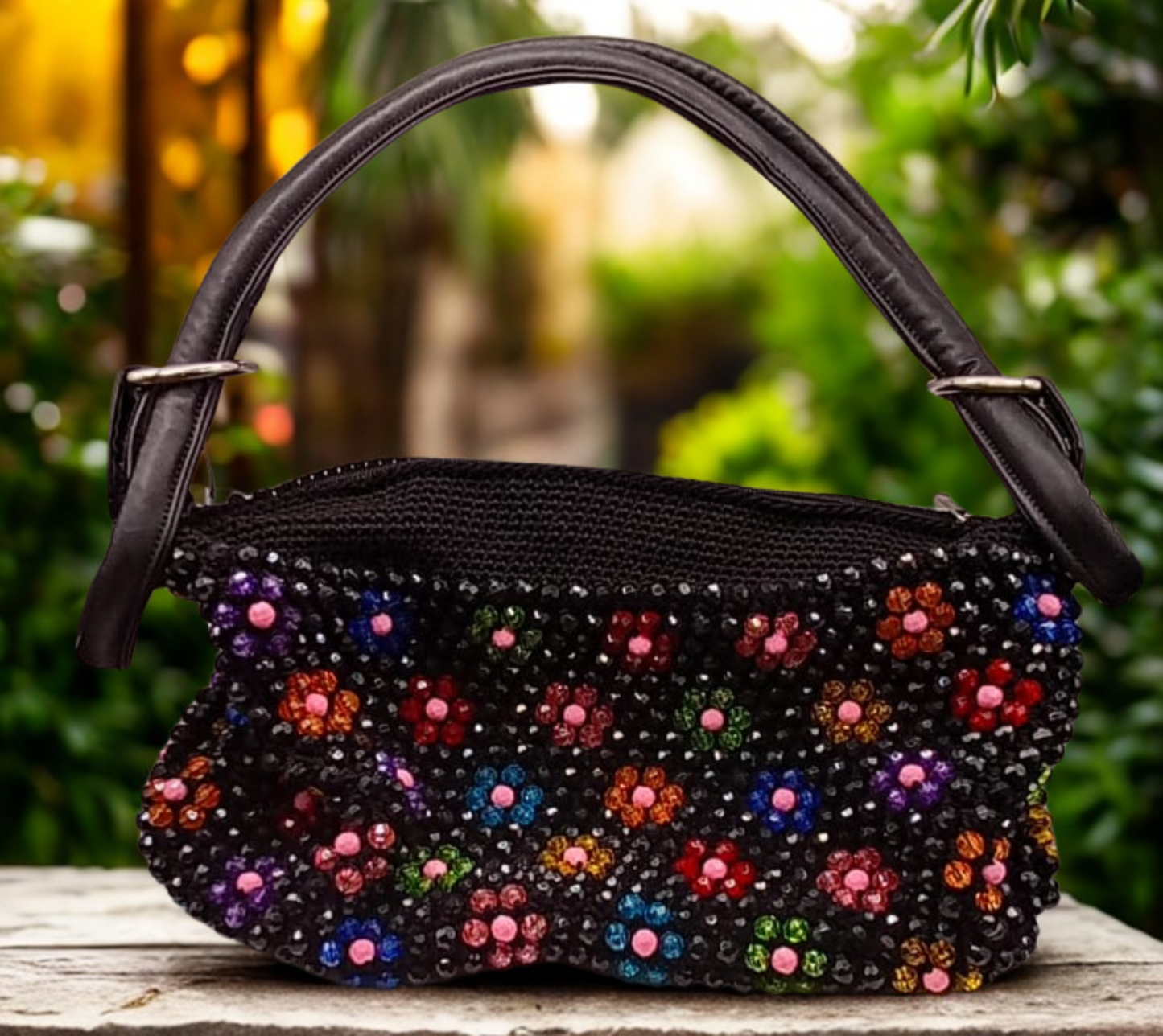 Bolso negro con flores multicolor artesanal, estilo boho chic.