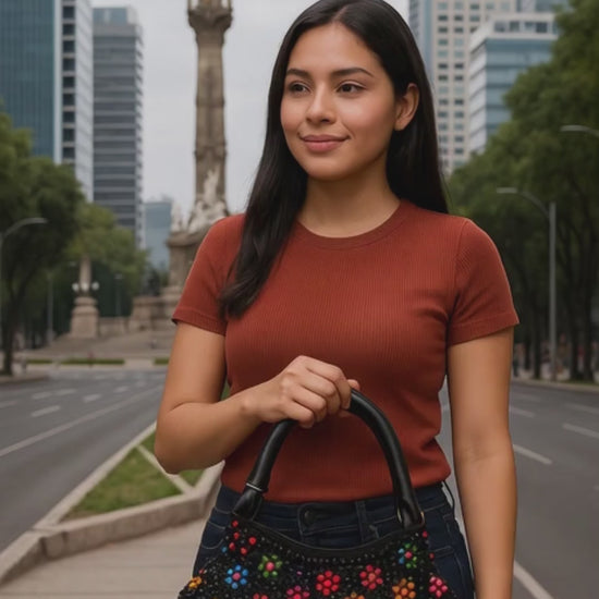 Bolso artesanal negro con flores multicolor, tejido elegante y único.